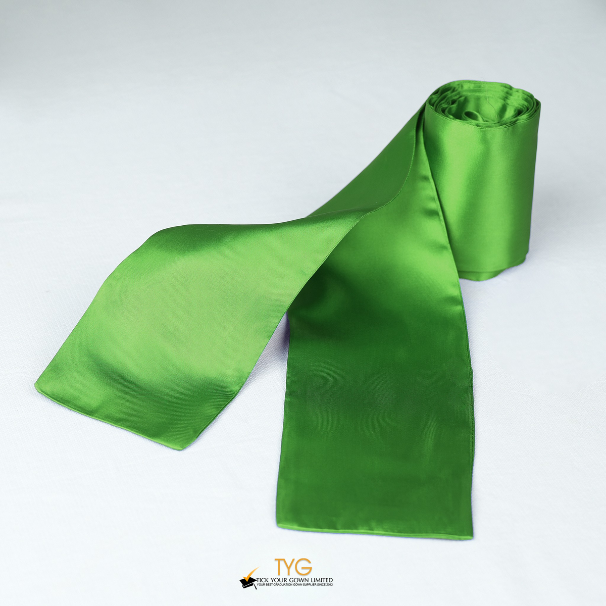 Green satin rolled graduation sash on a white background.