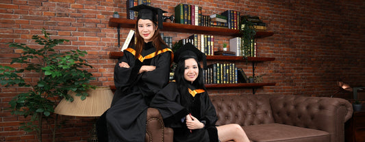 The models brandishing graduation gowns for the mortarboard sizing blog post