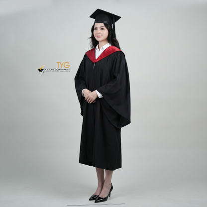 A profile view woman wearing a University of Edinburgh bachelor graduation gown and a black mortarboard cap stands against a light gray studio background. 

The gown has a red and black draped hood, and she is wearing a white collared shirt underneath.