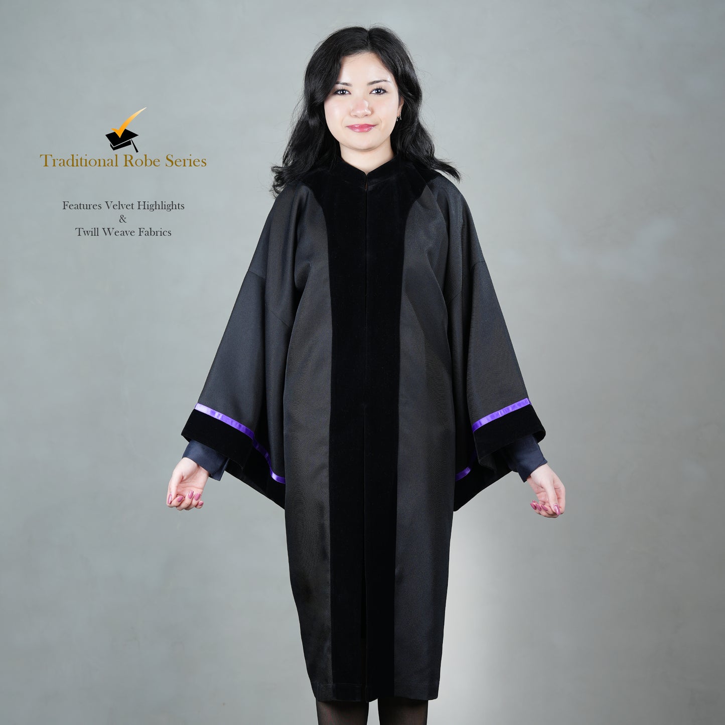 A person wearing a black bachelor graduation gown with velvet highlights, posed elegantly, without a hood or mortarboard.