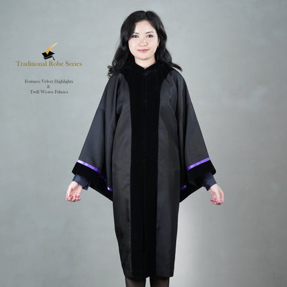 A person wearing a black bachelor graduation gown with velvet highlights, posed elegantly, without a hood or mortarboard.