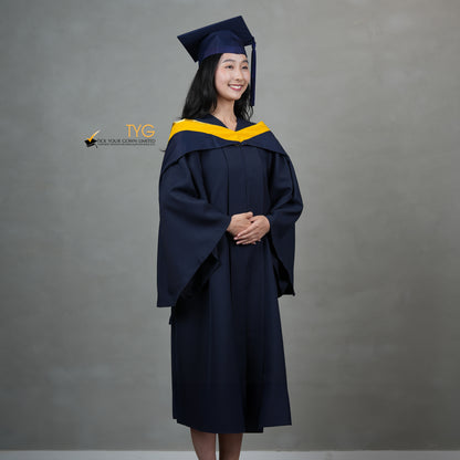 A full profile view of a graduate in a navy cap and gown with a yellow hood against a gray background