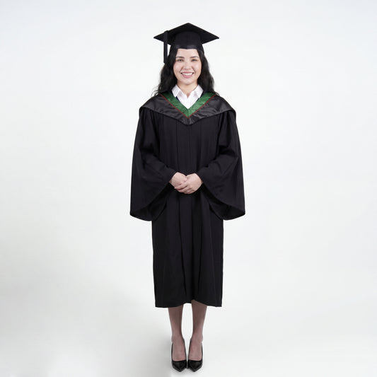 A woman wearing a black graduation gown and matching mortarboard cap stands against a light gray studio background.

The gown has a wide collar with green and brown trim accent hood, and the model is posed with hands clasped in front.