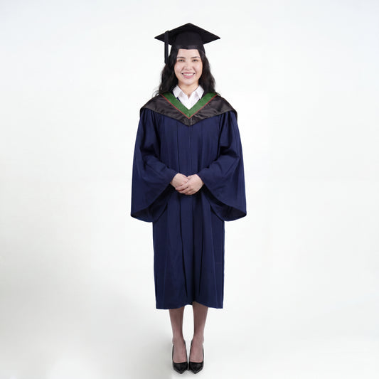 A woman wearing a navy blue graduation gown and matching mortarboard cap stands against a light gray studio background.

The gown has a wide collar with green and brown trim accent hood, and the model is posed with hands clasped in front.