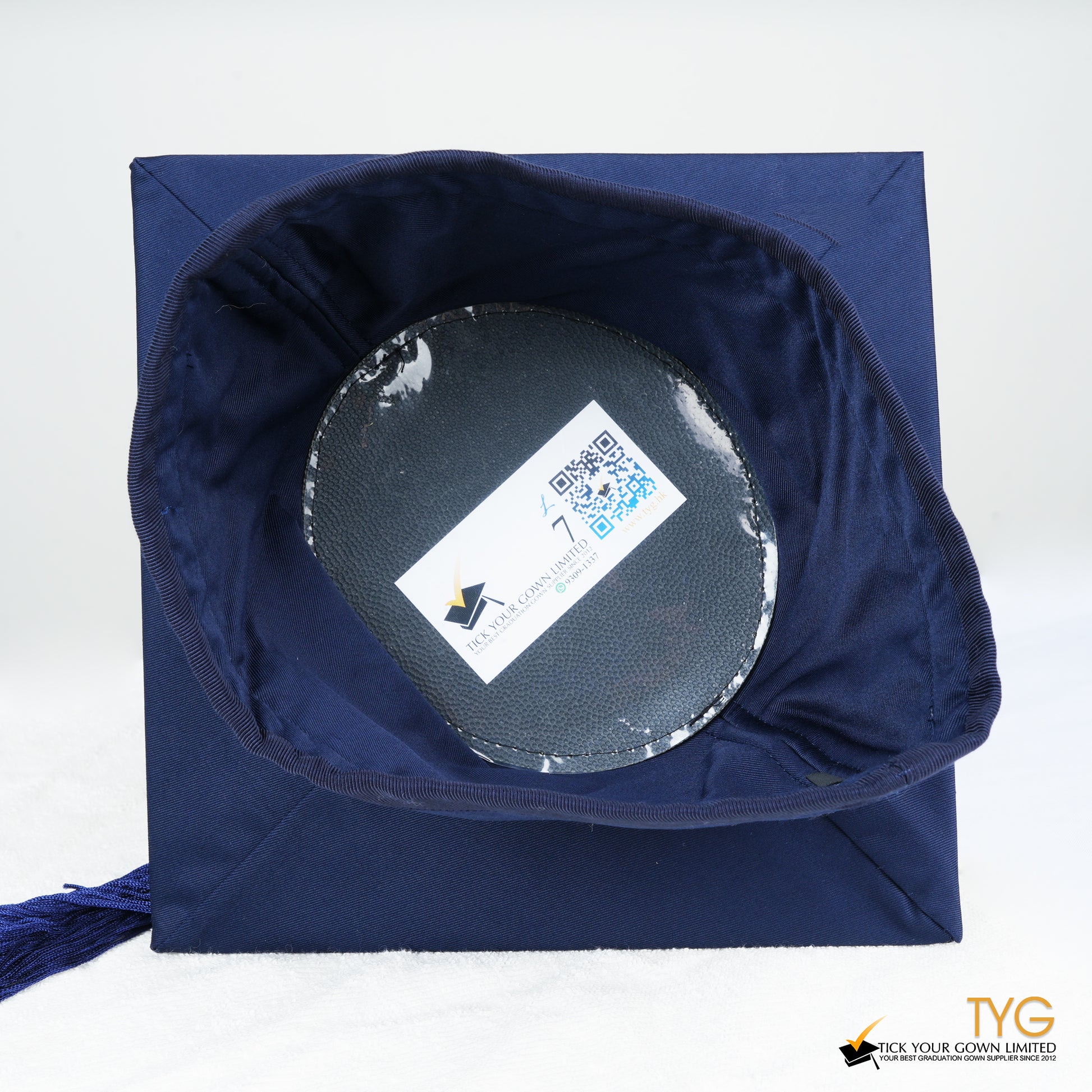 An inside view of a blue graduation cap with a blue tassel on a white background.