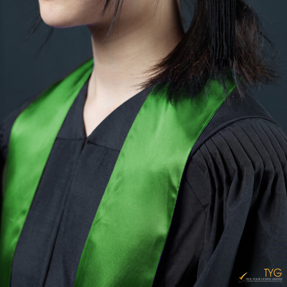 Person wearing a black graduation gown with a green graduation sash on a dark background
