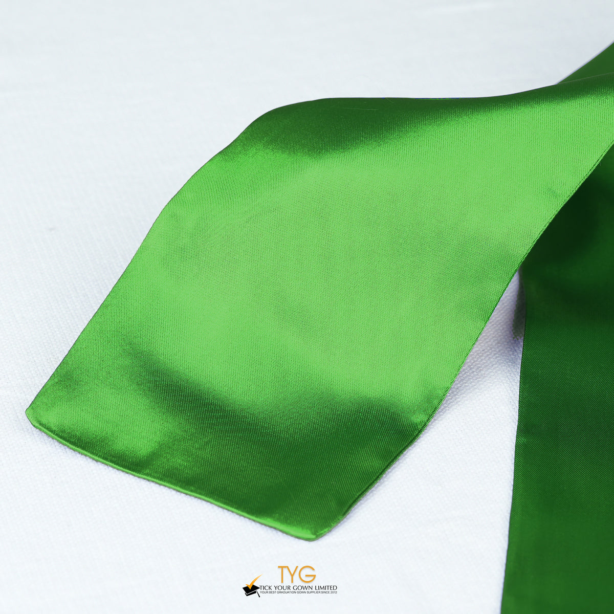 Detailed view of a green graduation sash fabric on a white background.