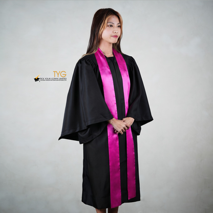 Profile view of a person wearing a black graduation gown with a pink graduation sash on a gray background