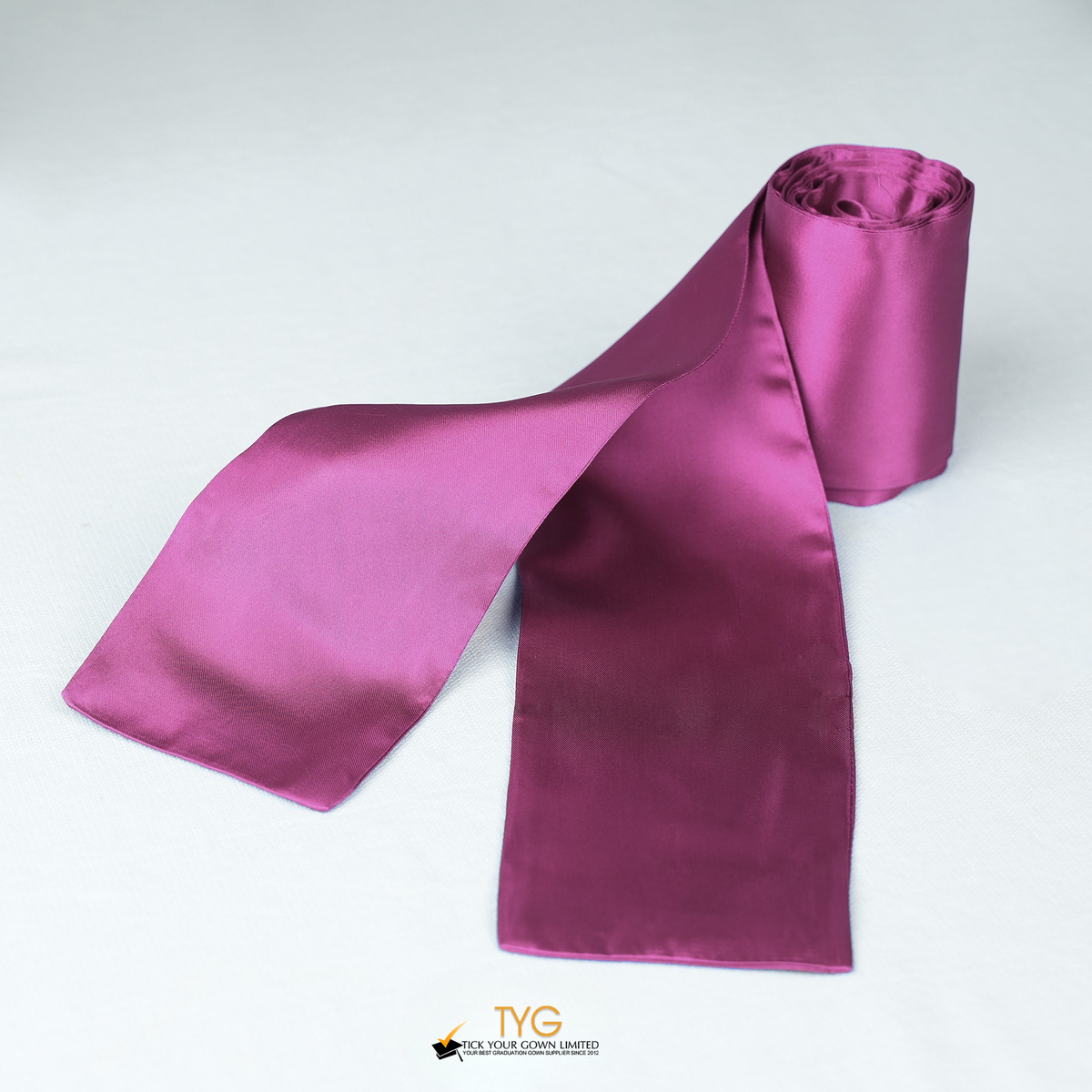 Pink satin rolled graduation sash on a white background.