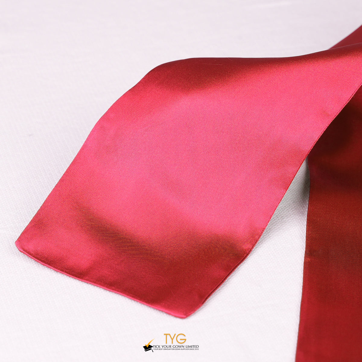 Detailed view of a red graduation sash fabric on a white background.