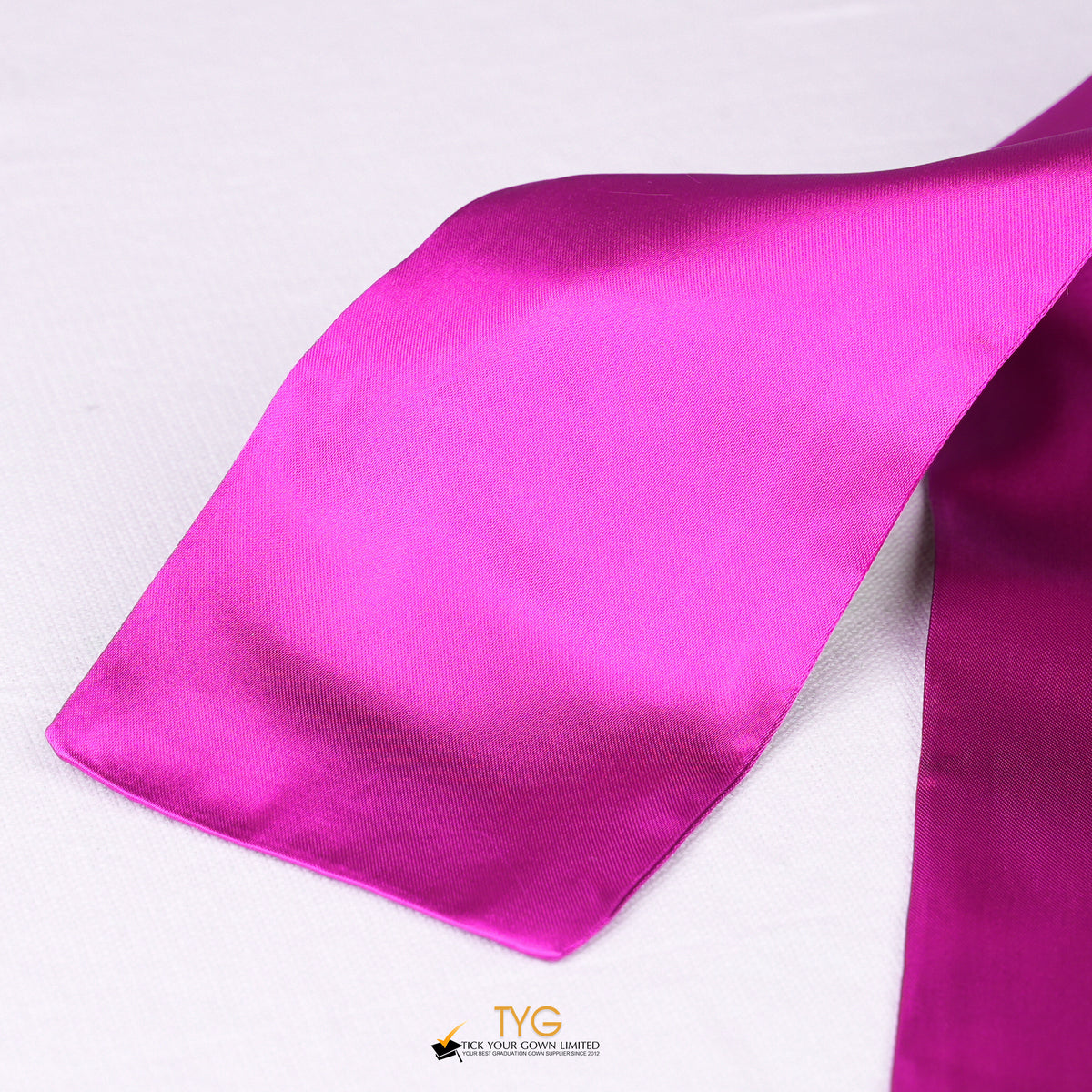 Detailed view of a pink graduation sash fabric on a white background.