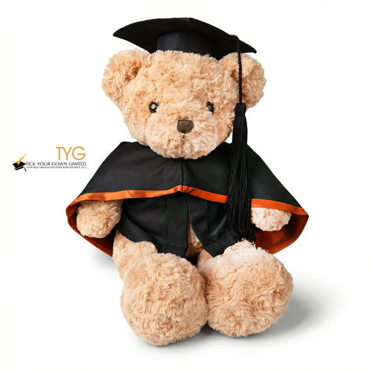 Graduation-themed teddy bear with cap and gown on a white background.