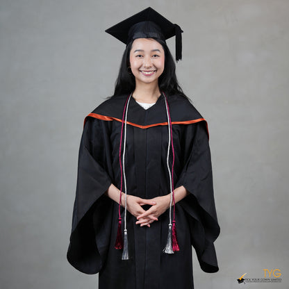 Graduate in black cap and gown with red honour cords on a gray background