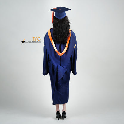 A full back view shot of a person in a navy blue graduation gown and an orange hood and with a mortarboard cap with an orange tassel against a gray background.