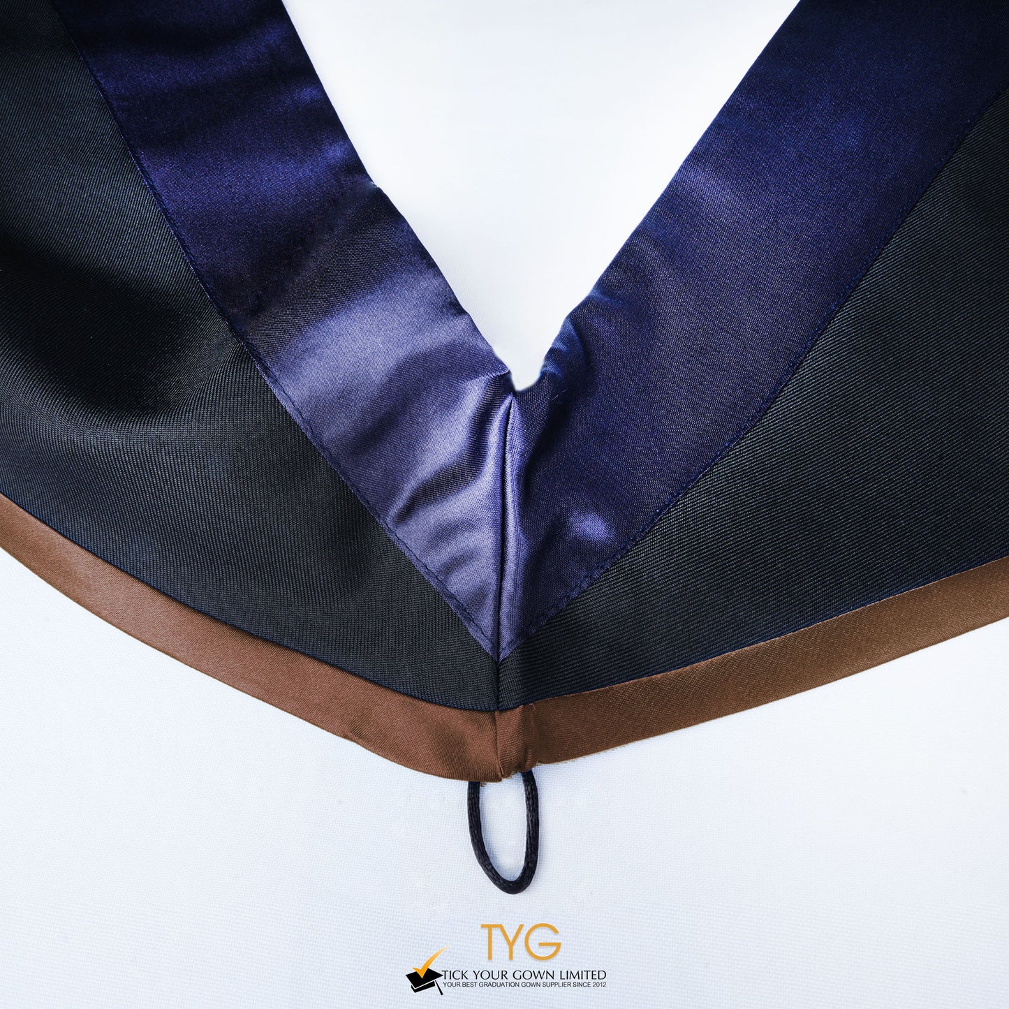 Close-up of a master's graduation hood with black body, dark navy blue satin hood and brown lining.