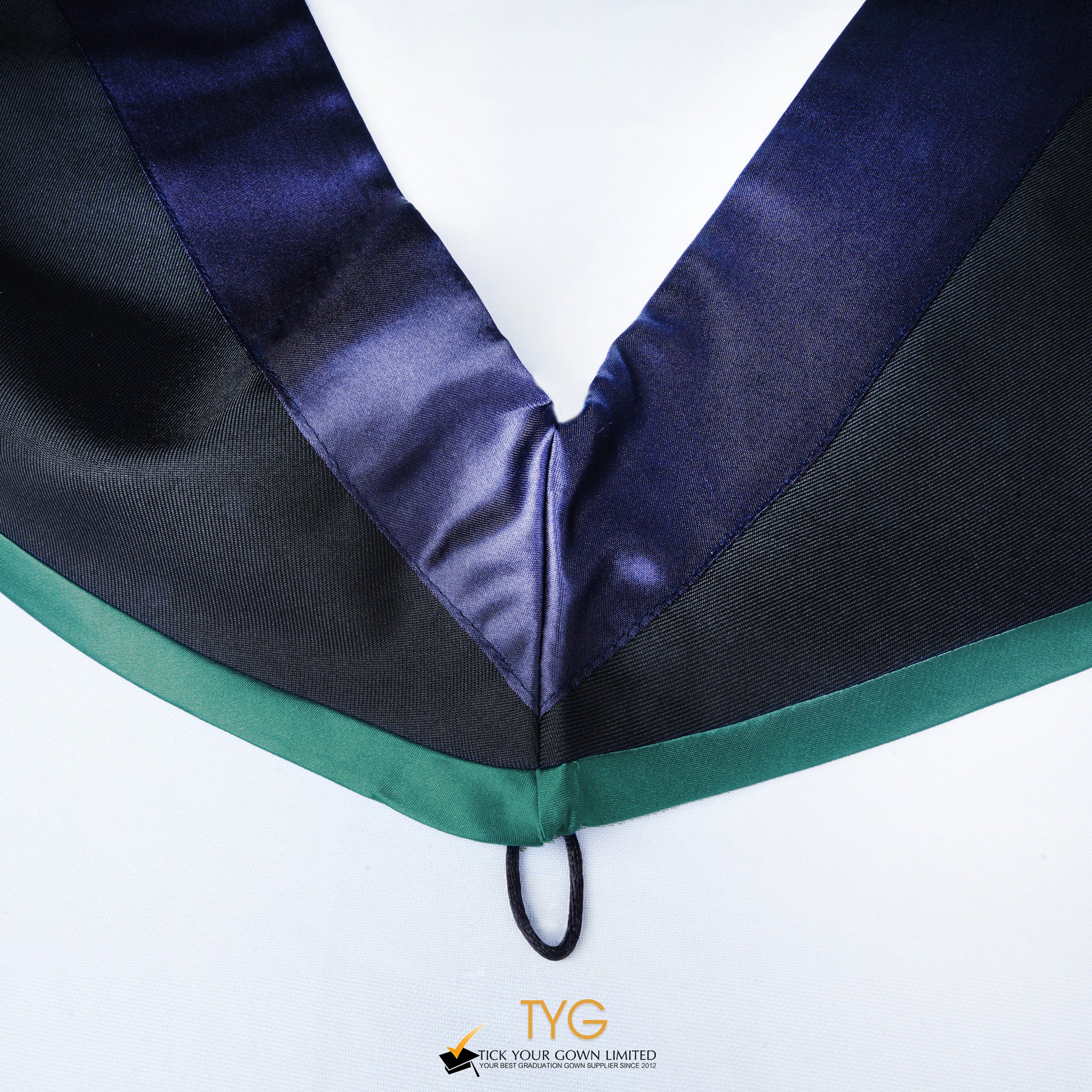 Close-up of a master's graduation hood with black body, dark navy blue satin hood and emerald lining.