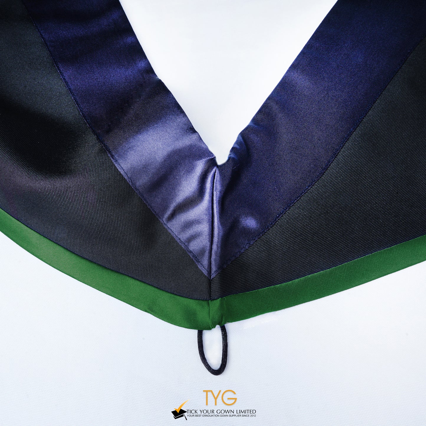 Close-up of a master's graduation hood with black body, dark navy blue satin hood and green lining.