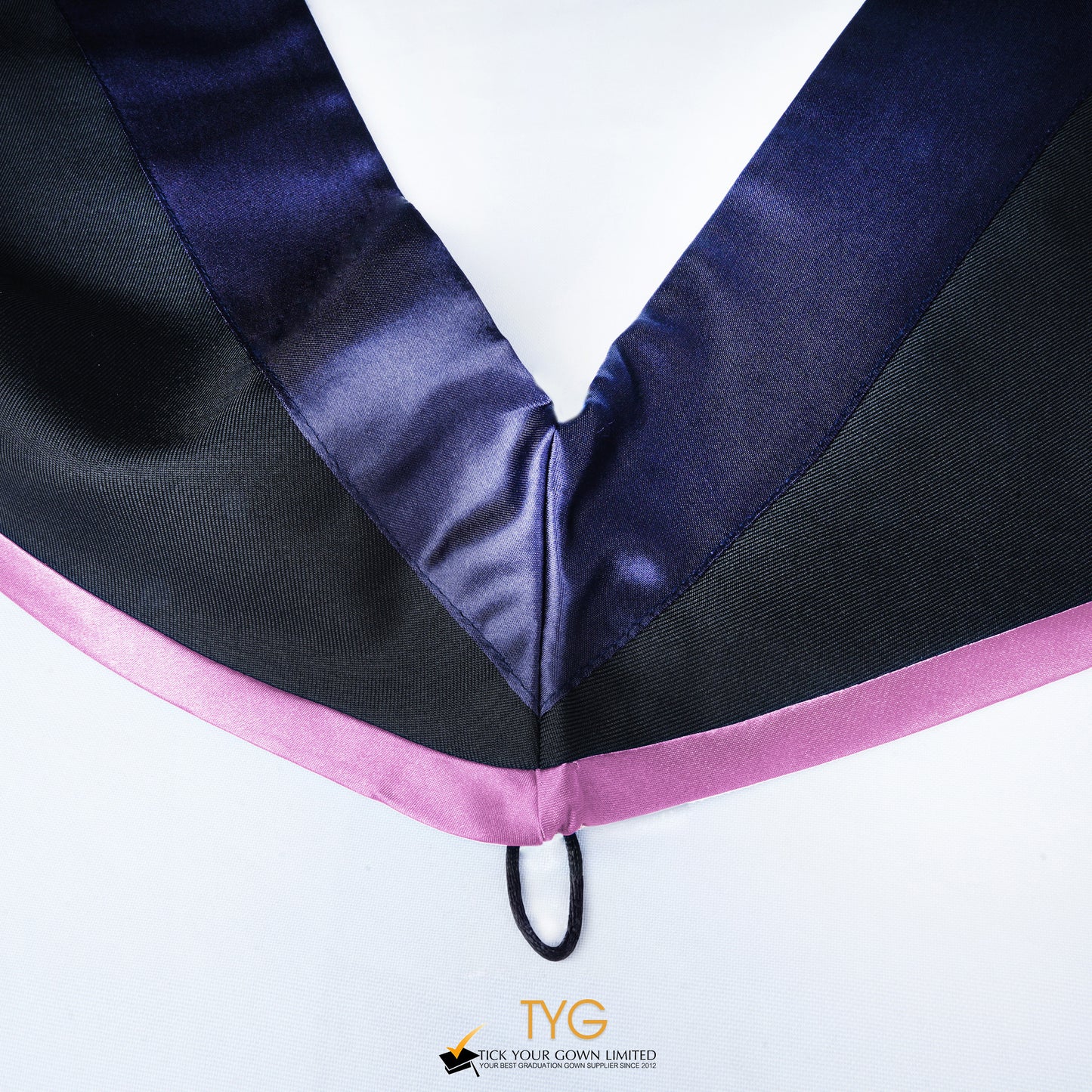 Close-up of a master's graduation hood with black body, dark navy blue satin hood and lilac lining.