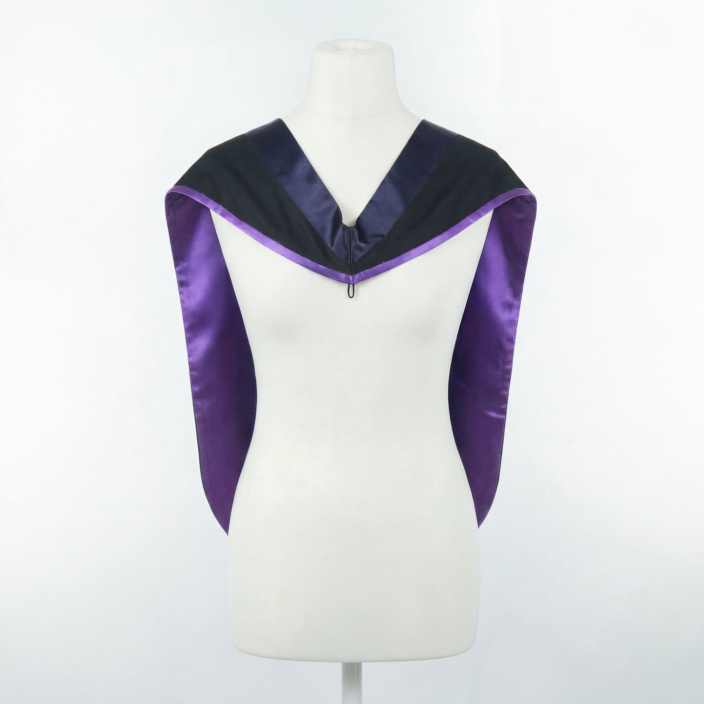 Master's graduation hood displayed on a mannequin showing full shape with black body, dark navy blue hood, and purple satin lining.