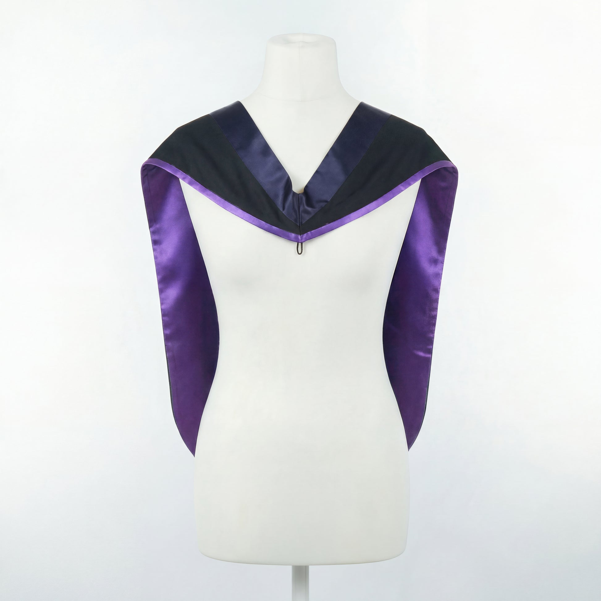 Master's graduation hood displayed on a mannequin showing full shape with black body, dark navy blue hood, and purple satin lining.