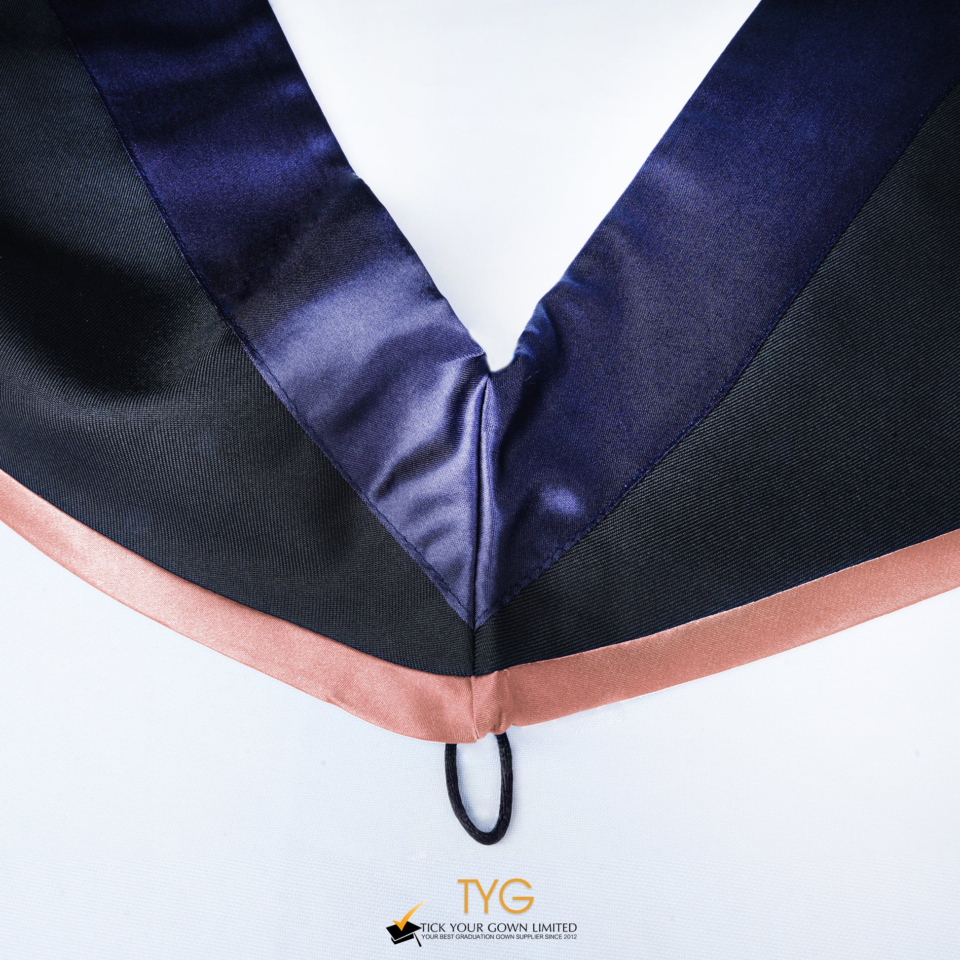Close-up of a master's graduation hood with black body, dark navy blue satin hood and salmon pink lining.