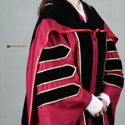 A detailed profile view of a person wearing a doctoral graduation gown in maroon with black velvet panels, matching black velvet sleeve bars in gold trim