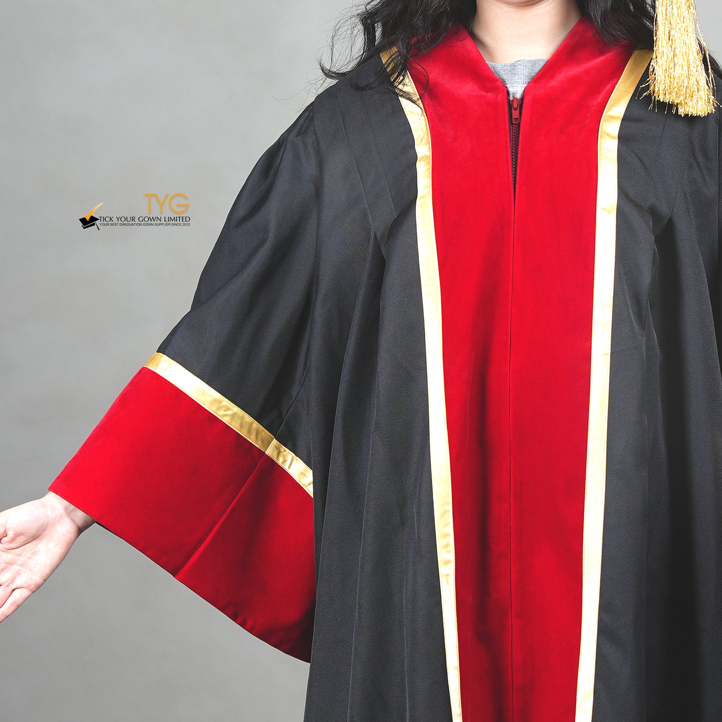 Detailed front view of a Black and red academic gown with gold trim on a gray background