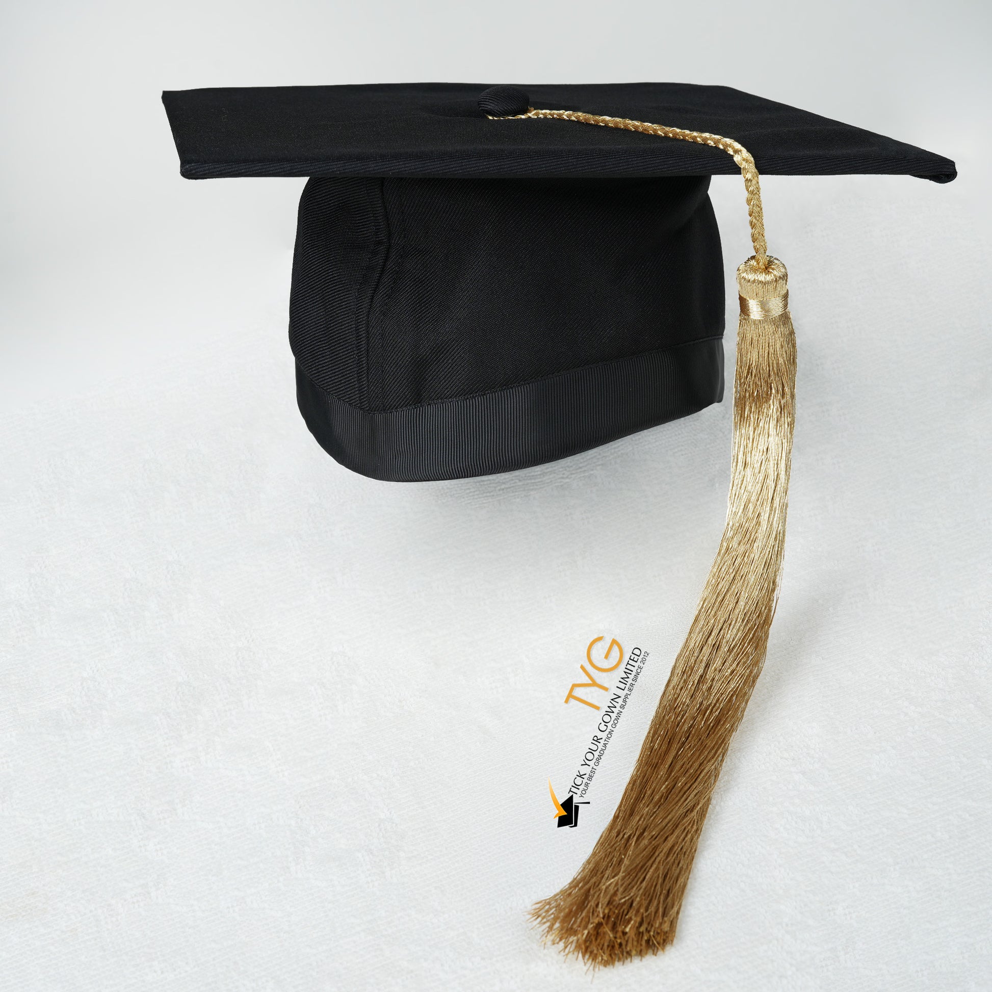 Black graduation cap with gold tassel on a white background