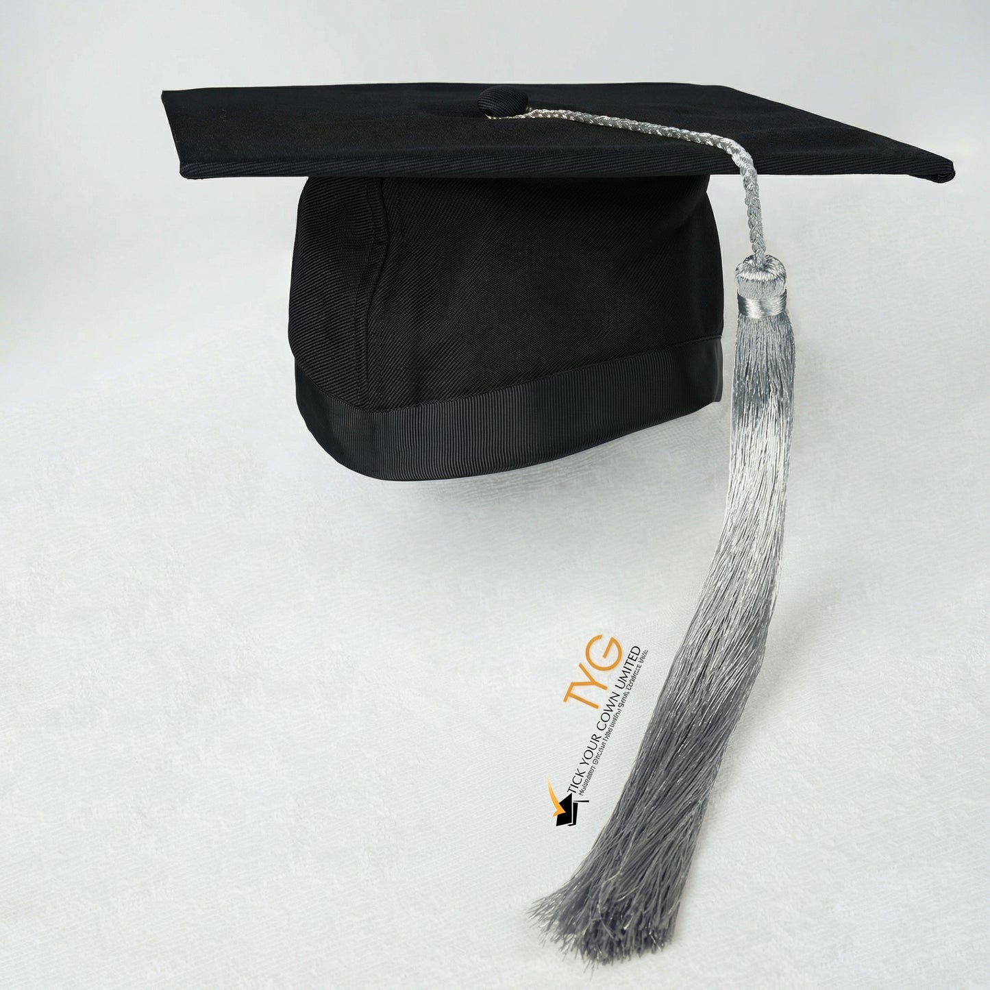 Black graduation cap with silver tassel on a white background